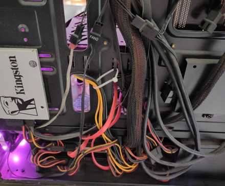 The inside of a PC with many colorful and messy cables.