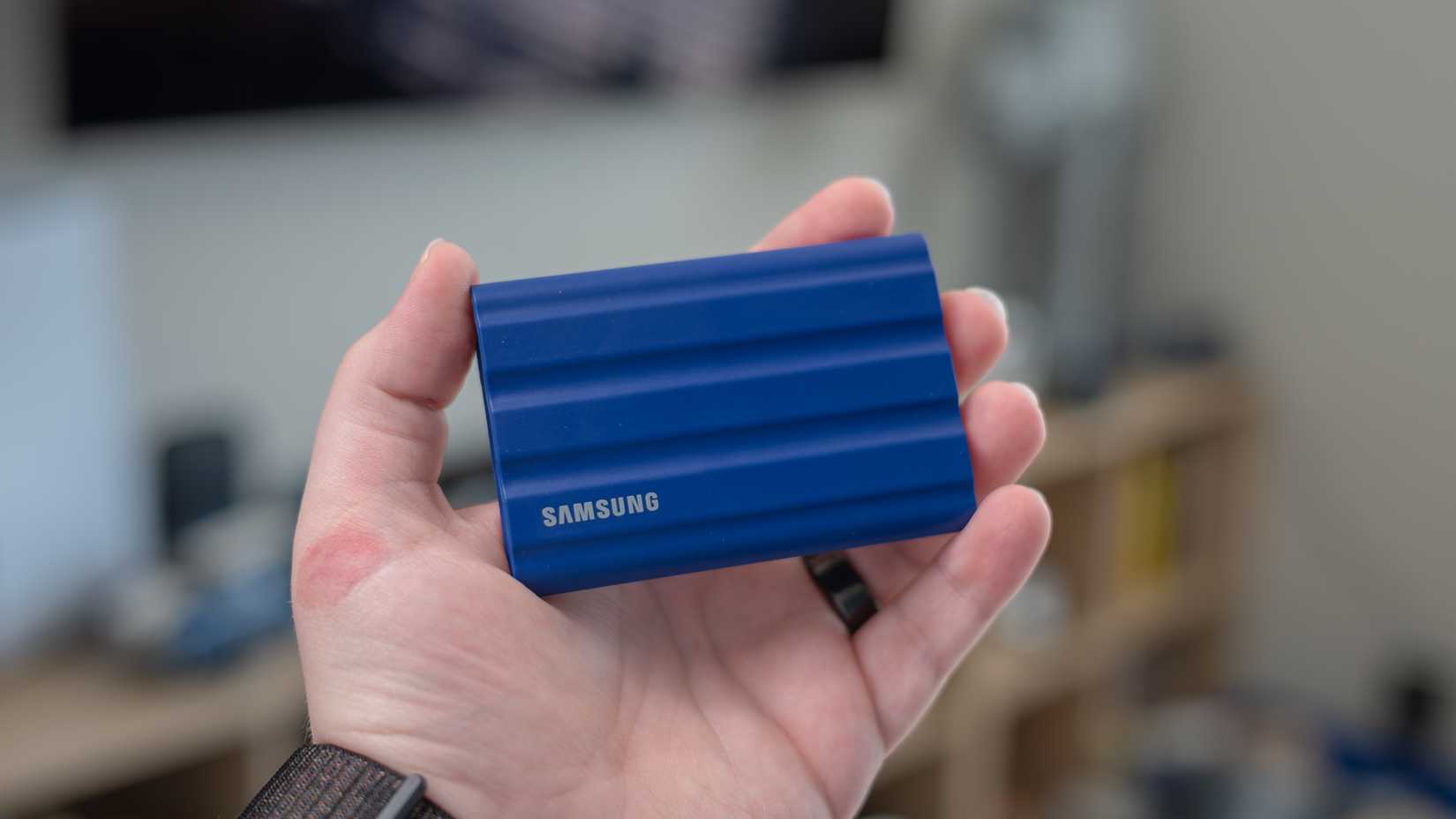 Samsung T7 Shield portable SSD held in a person