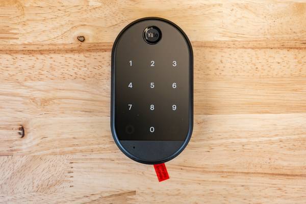 A Yale smart lock keypad on a table.