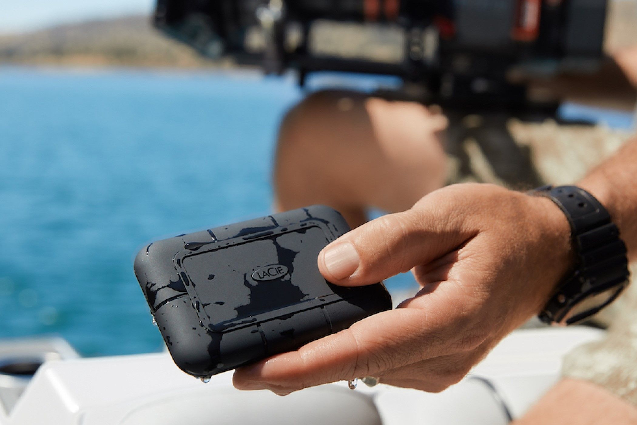 A person holding an LaCie Rugged SSD Pro.