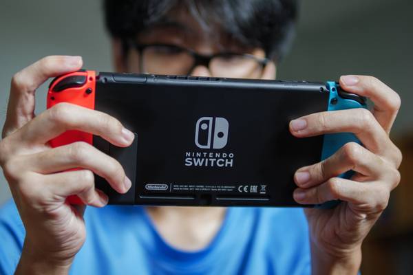 A man playing with a Nintendo Switch console in handheld mode.