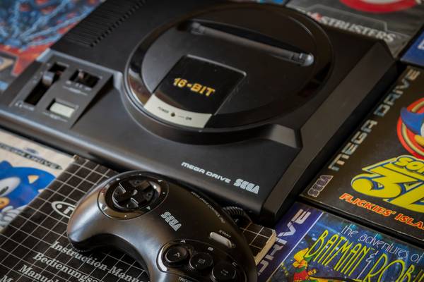 Sega Genesis console with some games and a controller.