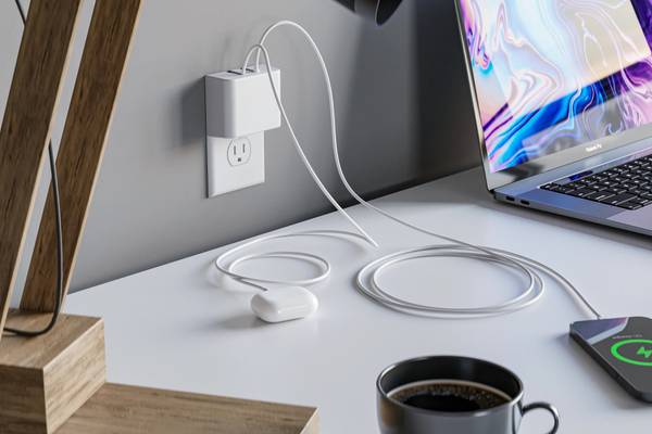 Permaplug wall charger next to a laptop and phone. 