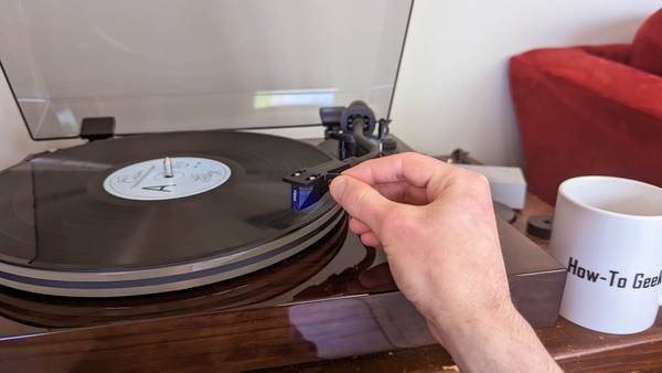 Person placing the needle of the Fluance RT85 vinyl turntable on a record