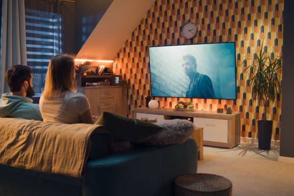 A couple watching a movie on a home theater setup.