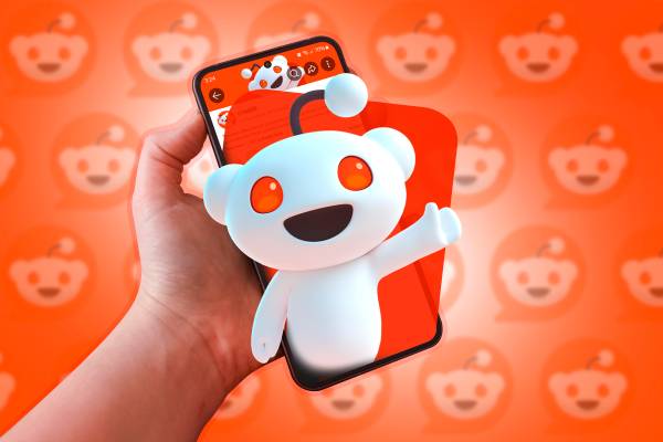 A phone with the Reddit mascot coming out of the screen.