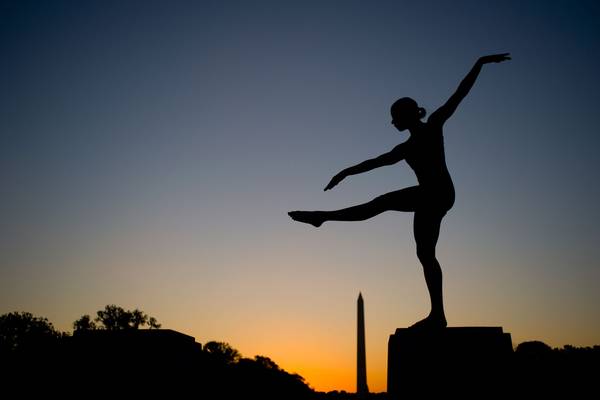 A dancer silhoutted against a sunrise in Washington DC.