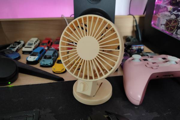 A small USB fan sitting on a table.