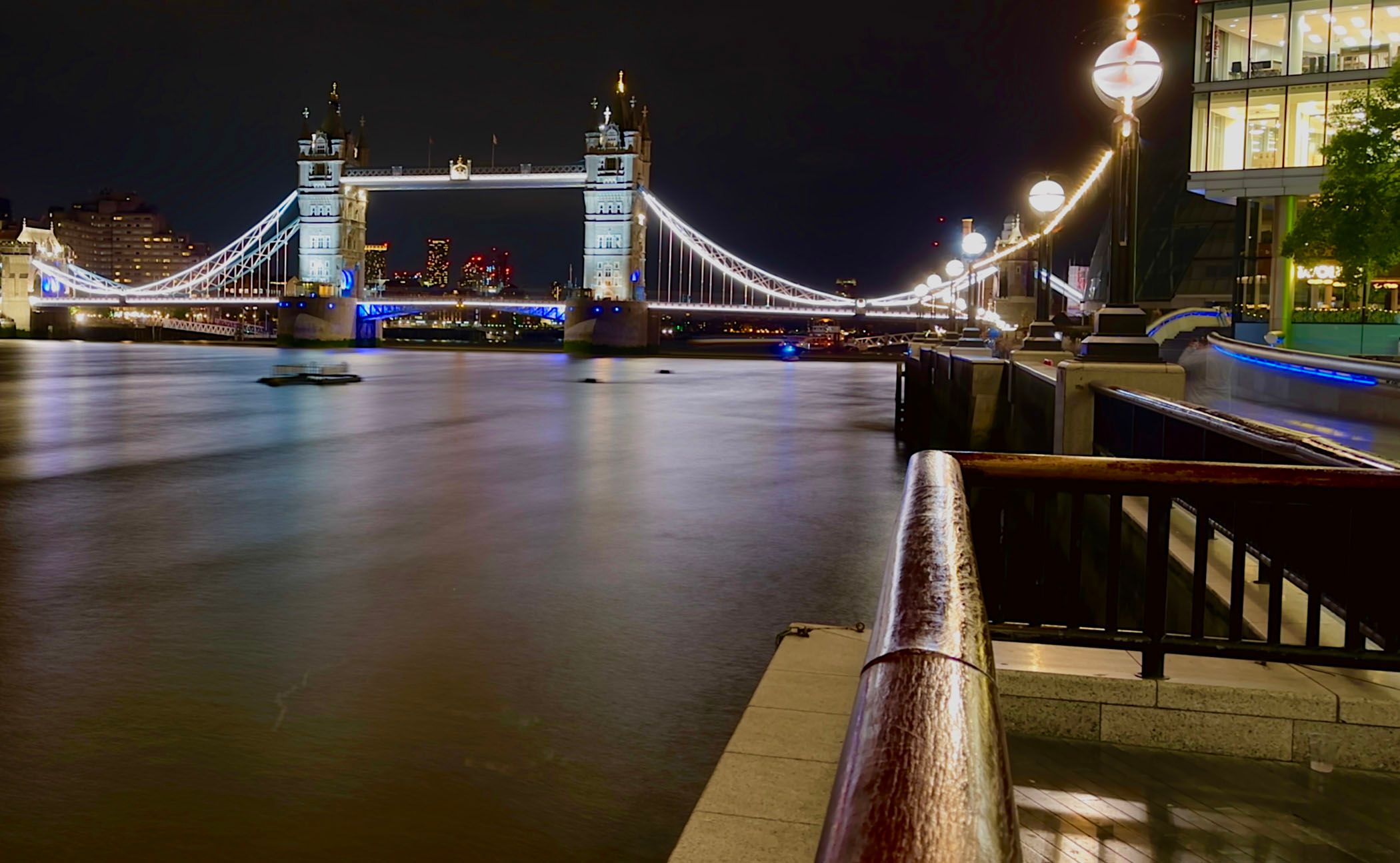 White light reflected on the surface of the Thames in front of London's Tower Bridge.