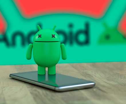 Android-маскот с глазами-крестиками лежит на телефоне на фоне логотипа Android.