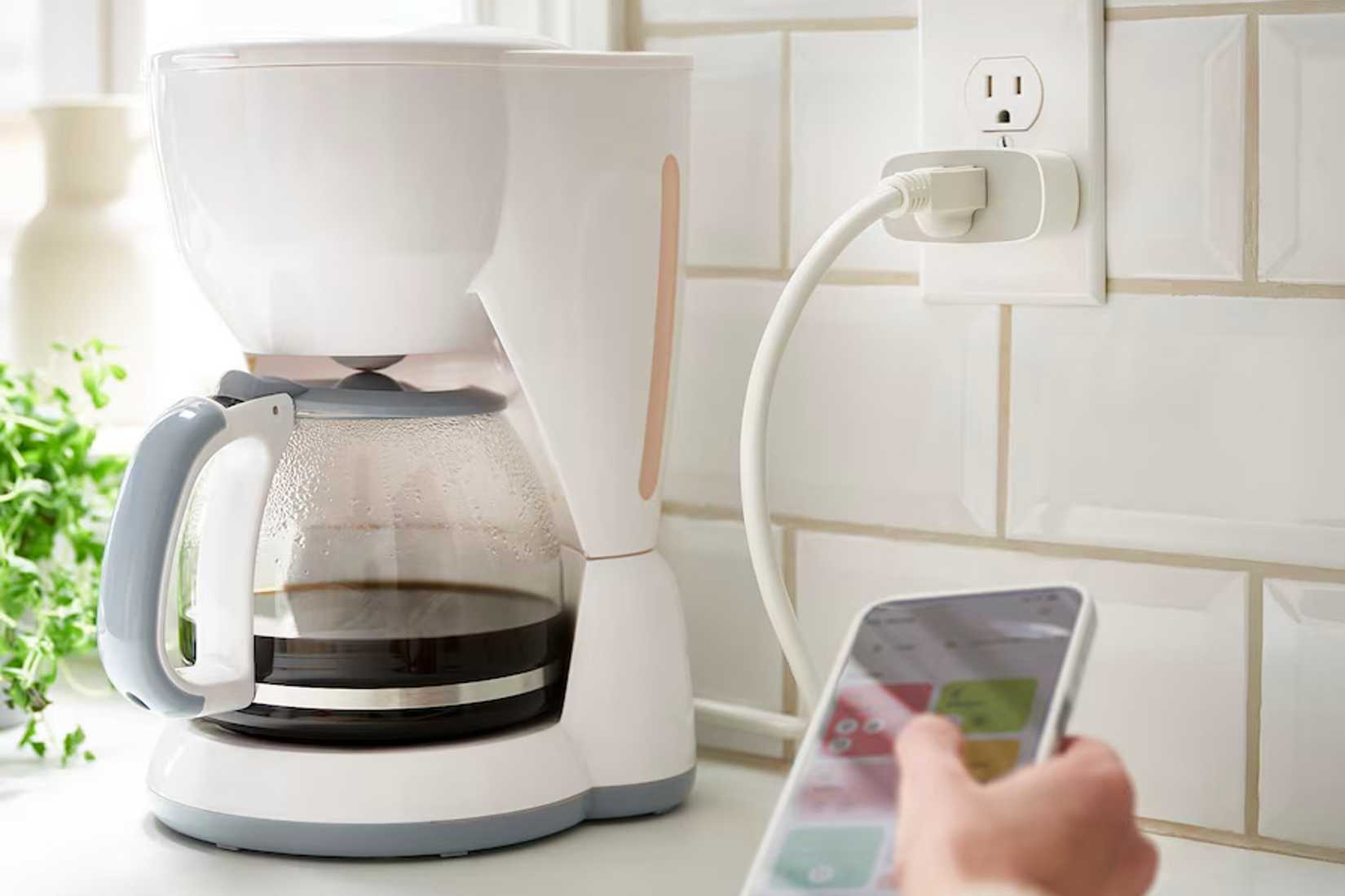 The inspelning smart plug connected to an outlet and a coffee maker.