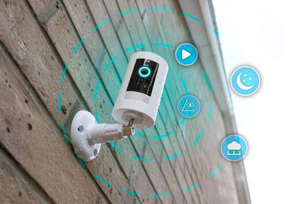 A security camera on an external wall with icons of some features it has.