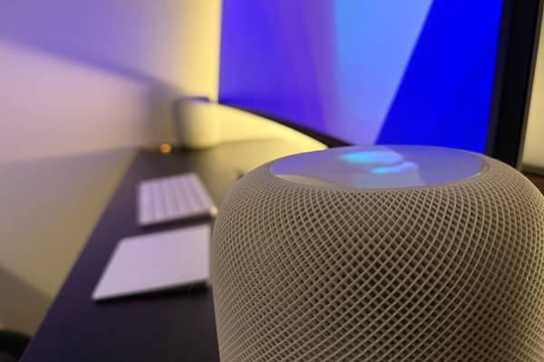 An original HomePod in white on a desk.