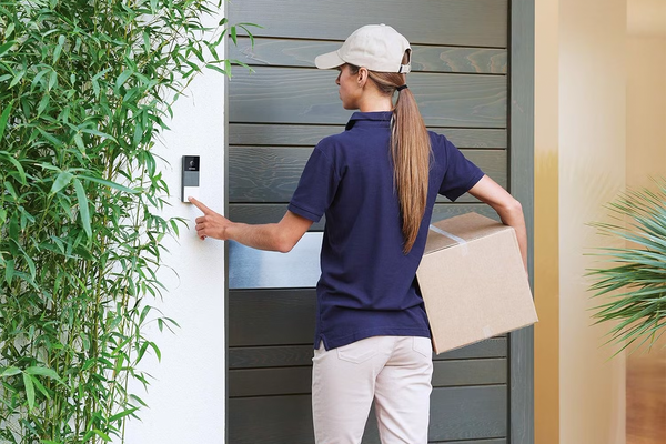 Delivery person ringing the doorbell with a package in her hand