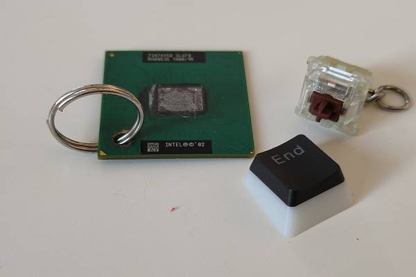 An old CPU and mechanical keyboard switch repurposed as keychain charms.