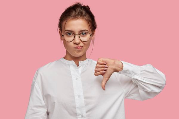 A woman making a thumbs-down gesture.