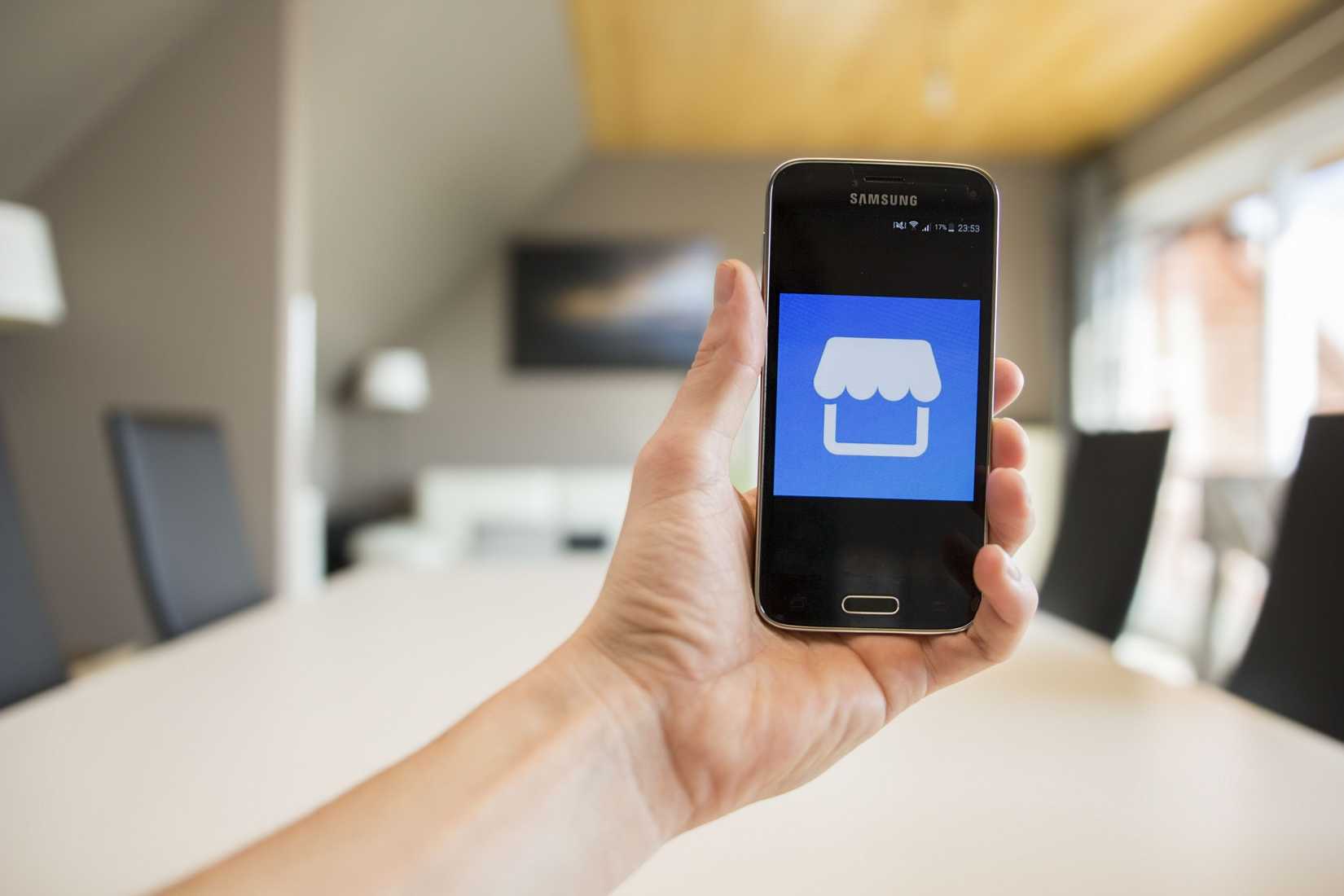 Смартфон Samsung Galaxy S5 mini и логотип Facebook Marketplace на экране.