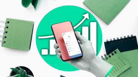 A hand holding a smartphone with office supplies in the background and a graph indicating increased productivity.
