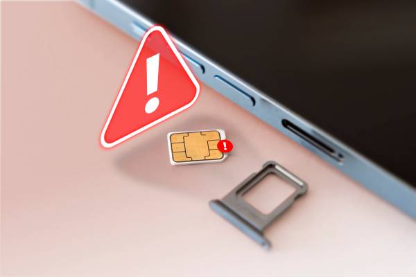 A SIM card next to a smartphone with a warning sign.