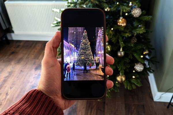 An iPhone with a photo of a Christmas tree on it.