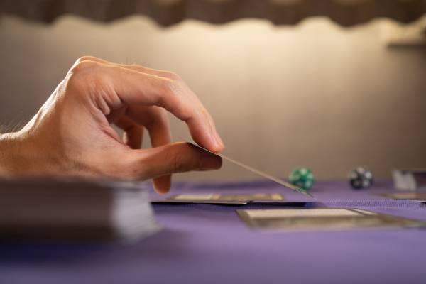 Playing a physical trading card game on a table.