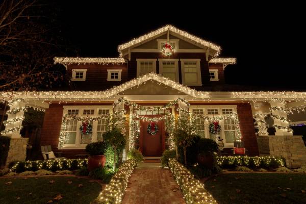 Suburban home at the holidays with lots of Christmas lights on.