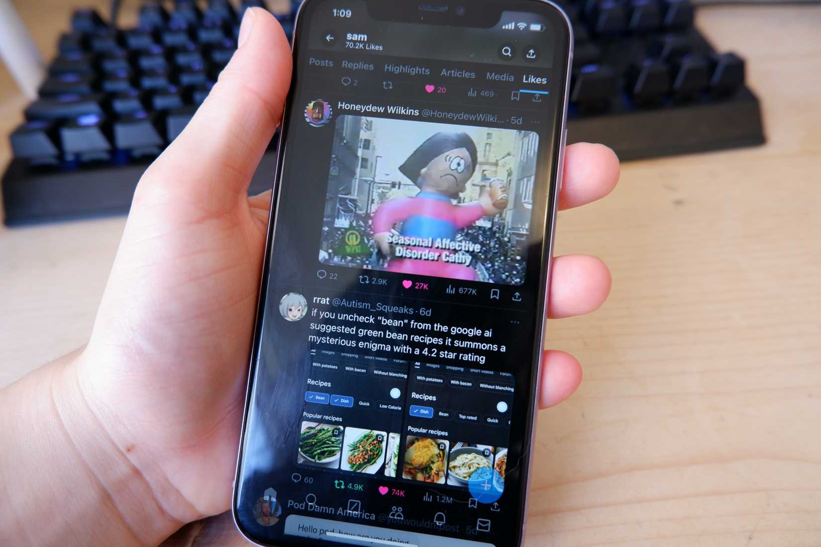 Uma mão segurando um iPhone 11 mostrando a guia X de curtidas.