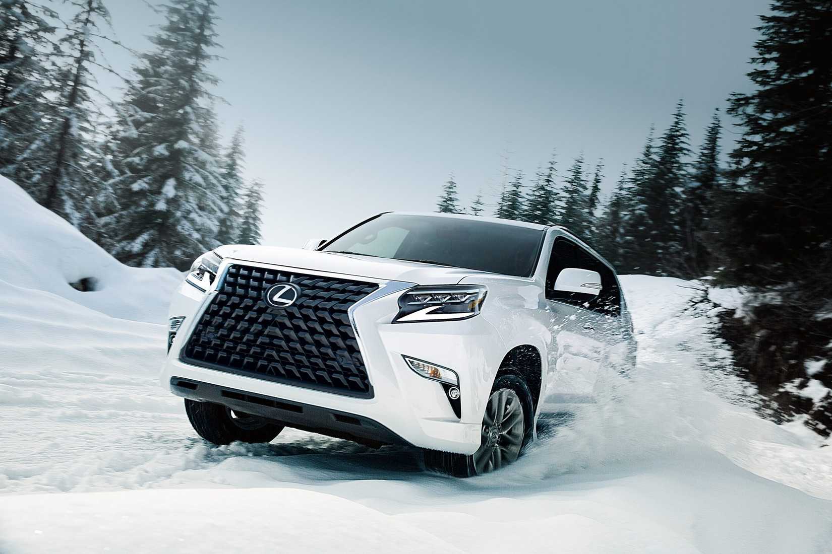 A white 2022 Lexus GX 460 pictured driving through the snow in a forested area.