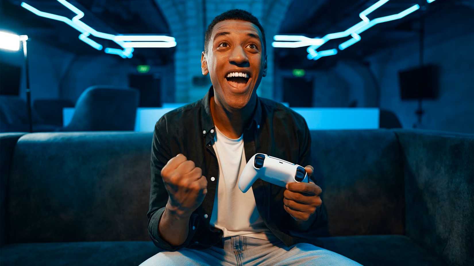 A happy man holding a video game controller.
