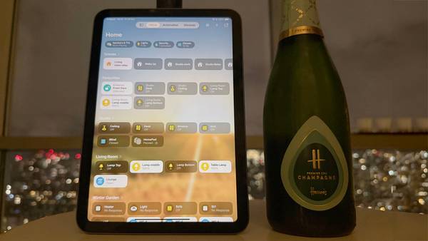 An iPad smart home control panel next to a bottle of champagne.