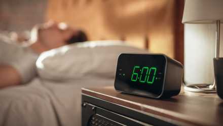Your telephone's location is a great house superpower—listed below are 7 automations to arrange now Man in bed next to alarm clock at 6am.