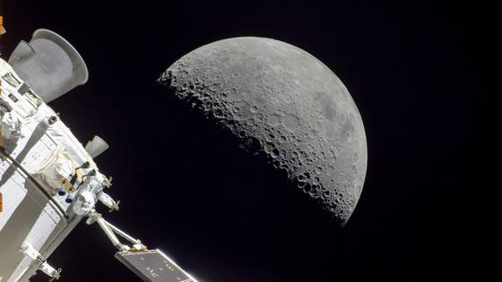 The Orion spacecraft floating through space with the Moon in the background.