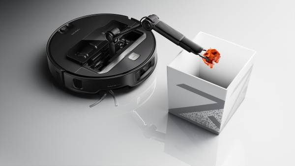 Roborock Saros Z70 Picking Up a Crumpled Paper With Its Robotic Arm