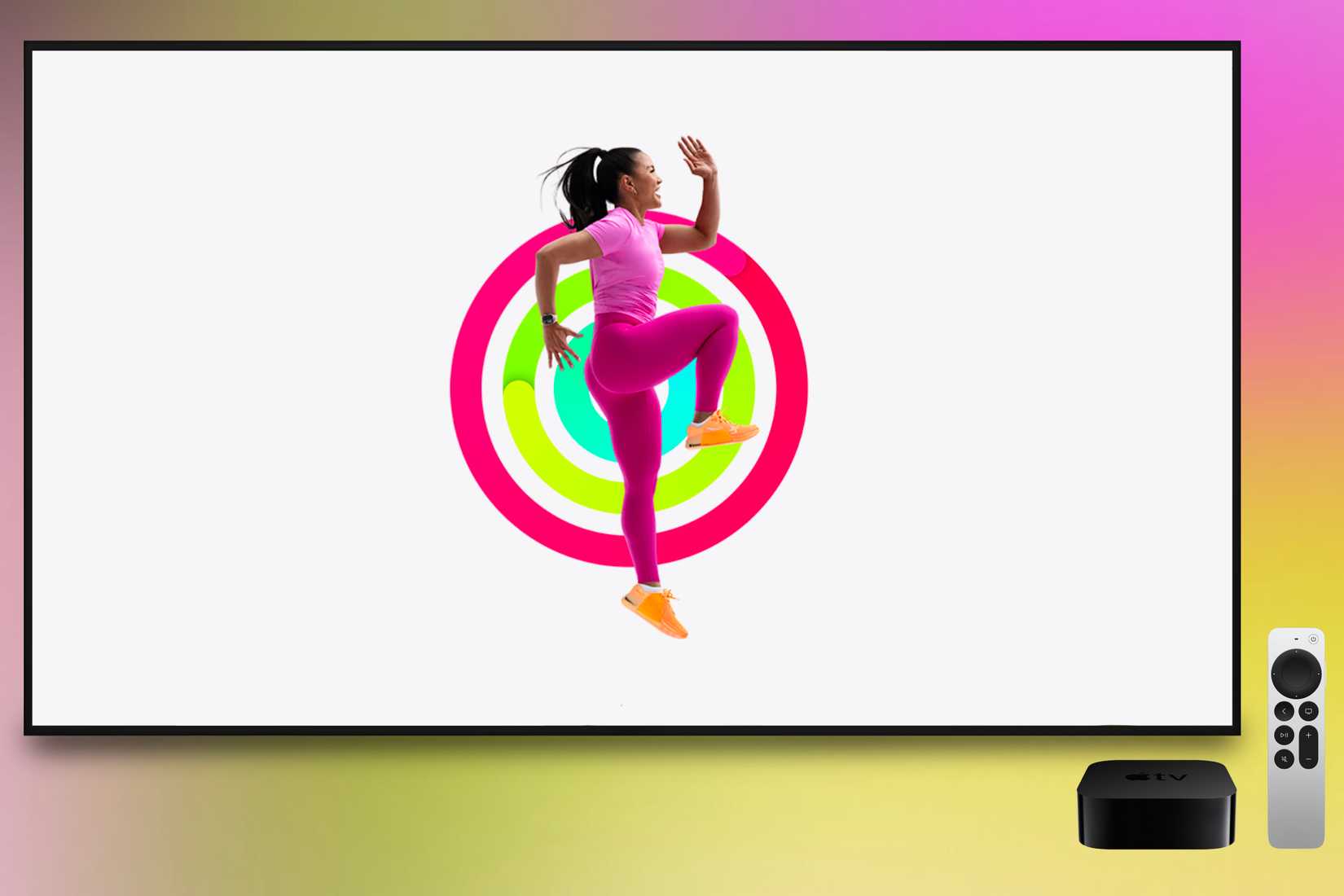 Un entrenador de Apple Fitness+ haciendo ejercicio frente a anillos de actividad cerrados mostrados en un Apple TV. Una caja de Apple TV y un control remoto están presentes frente a un fondo colorido.