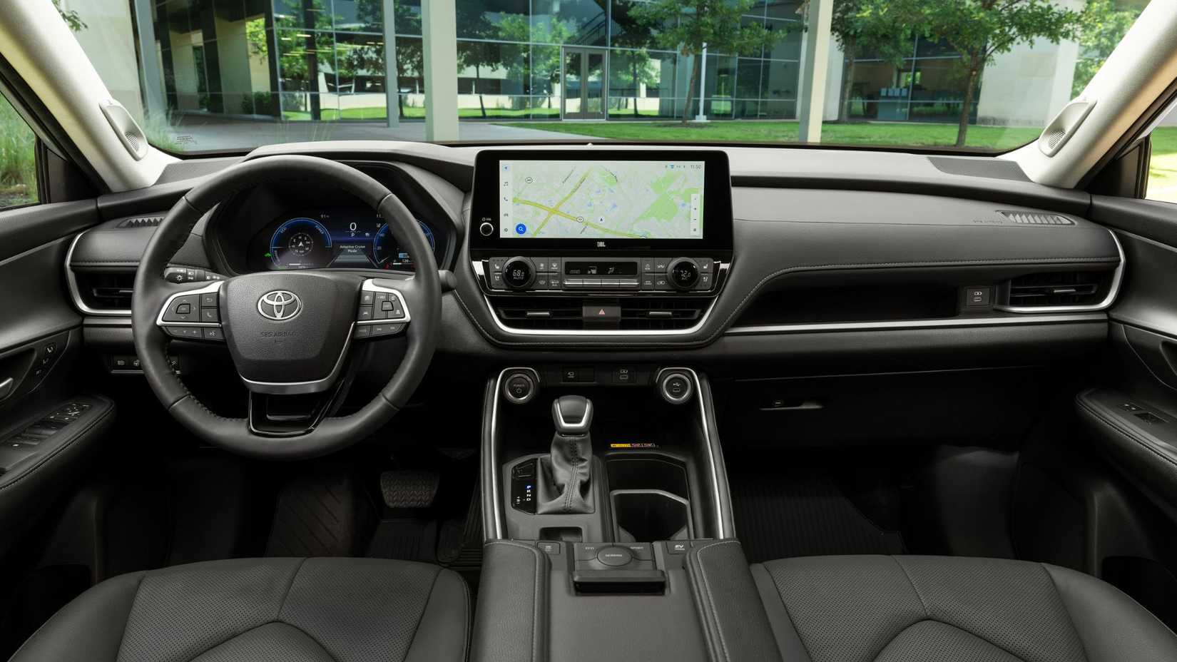 Interior de una Toyota Grand Highlander 2025 que muestra el tablero que incluye el volante y la pantalla de información y entretenimiento.