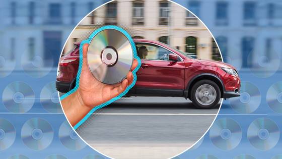 A red SUV driving on a road and a hand holding a CD in the foreground.