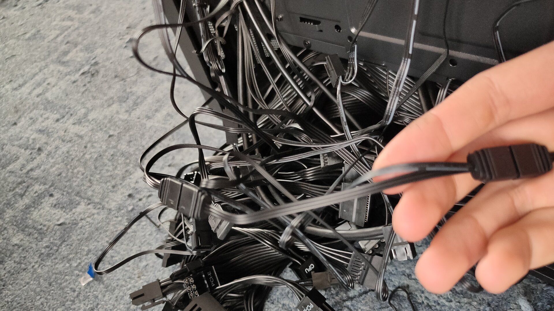 A mess of black computer cables protruding from the computer case.