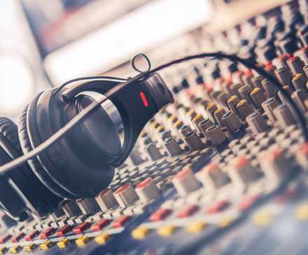 Mixer and professional headphones in the recording studio. Sound mixing desk. Sound mastering for radio and tv broadcast.