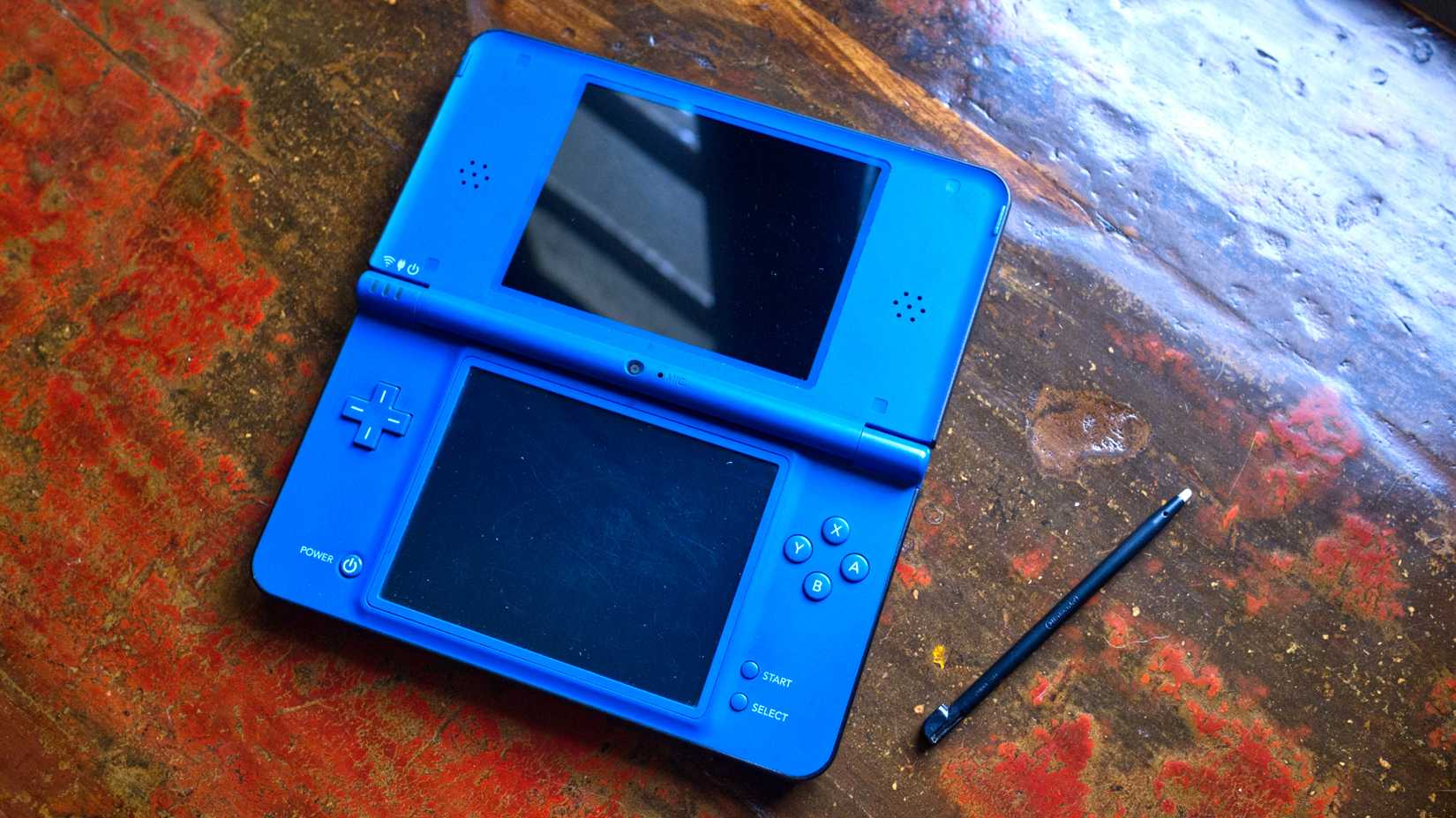 Blue Nintendo DSi XL open with stylus.