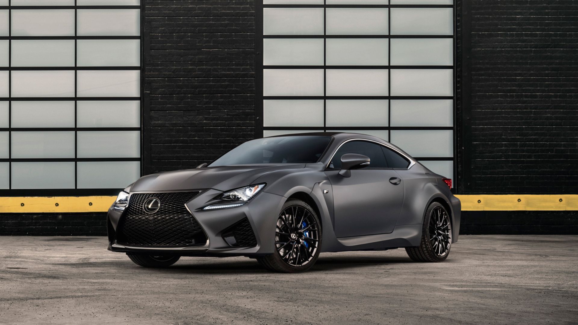 Front 3/4 view of a gray 2018 Lexus RC F parked outside of a warehouse.