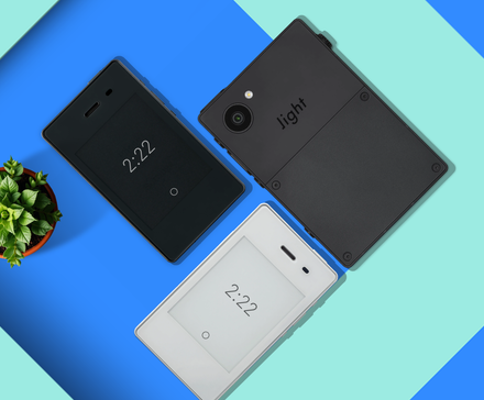 A minimalist scene with some minimalist phones and a flower vase.