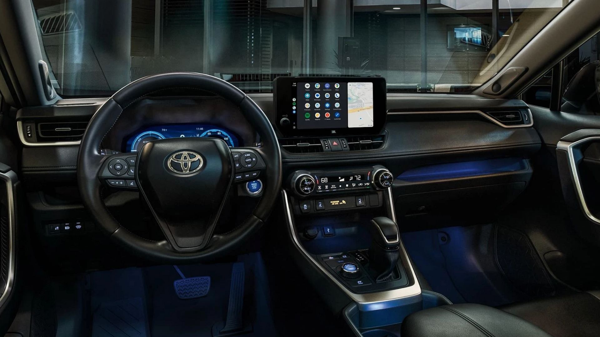 Close-up shot of the dashboard of a 2024 Toyota RAV4 at night with its ambient lighting.