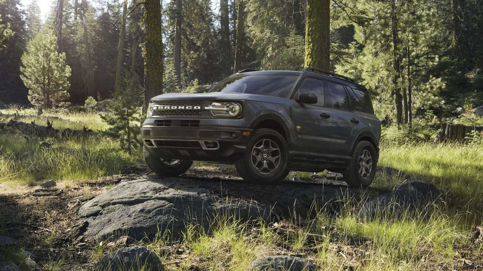 Avant 3/4 Vue sur un Ford Bronco Sport gris 2022 Gara sur un rocher dans une forêt.