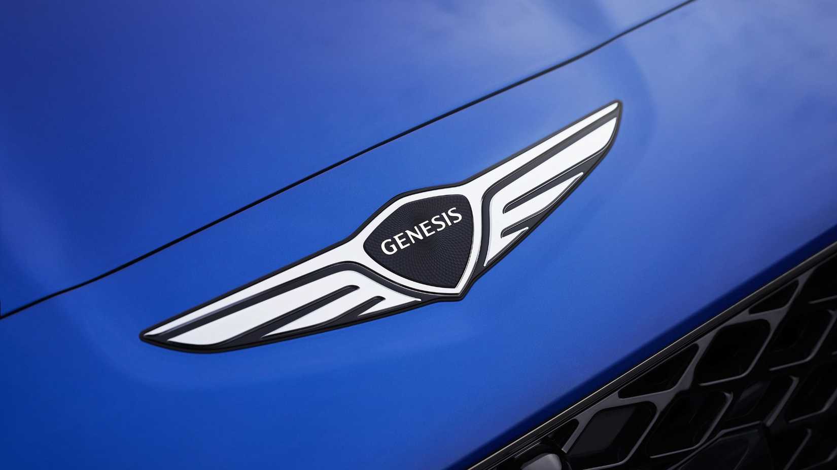 Gros plan de l’insigne sur le capot d’une Genesis G70 2025 bleue.
