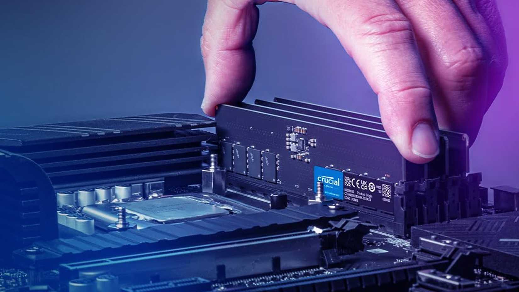 A hand installing a Crucial DDR5 RAM kit into a motherboard.
