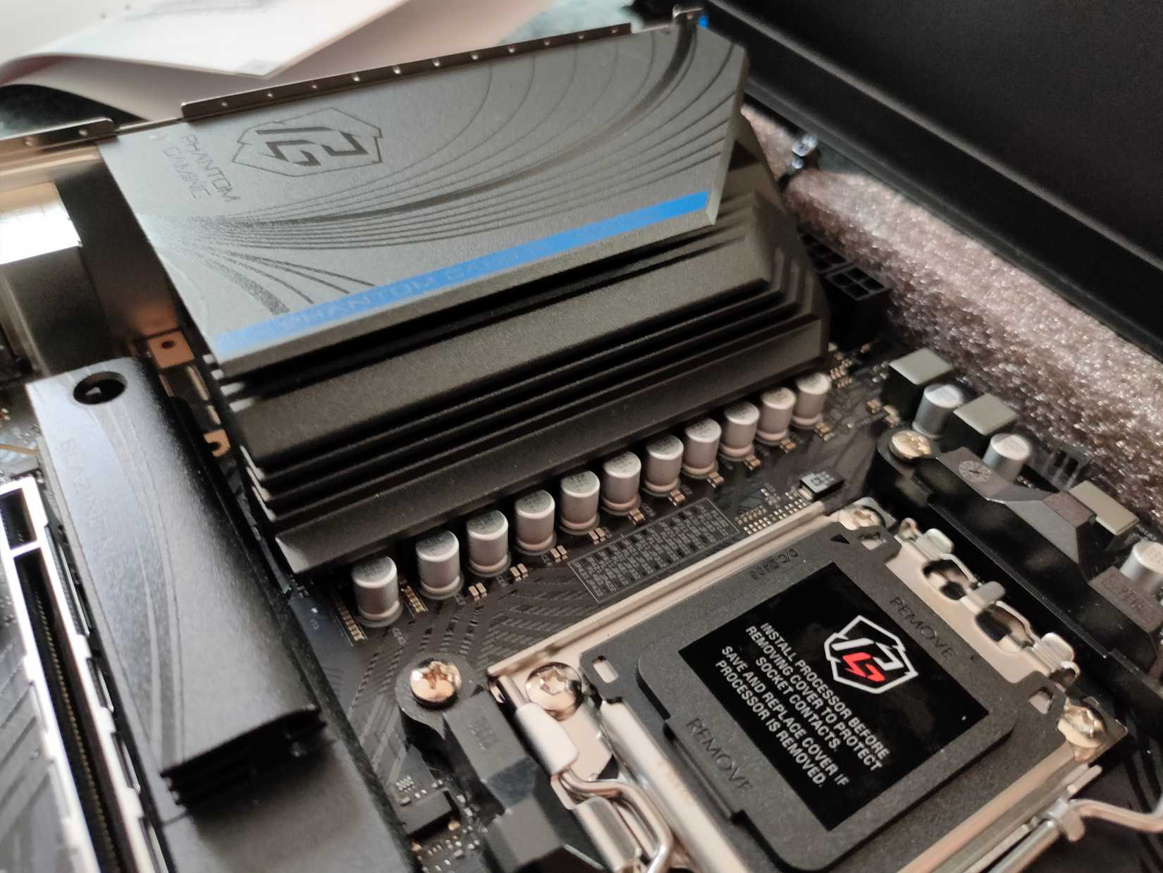 Um dissipador de calor cobrindo os VRMs de uma placa -mãe ASROCK B650M PG RIPTIDE.