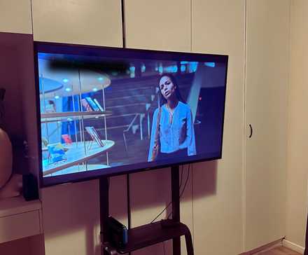 Photo of a TV in a bedroom on a rolling stand.