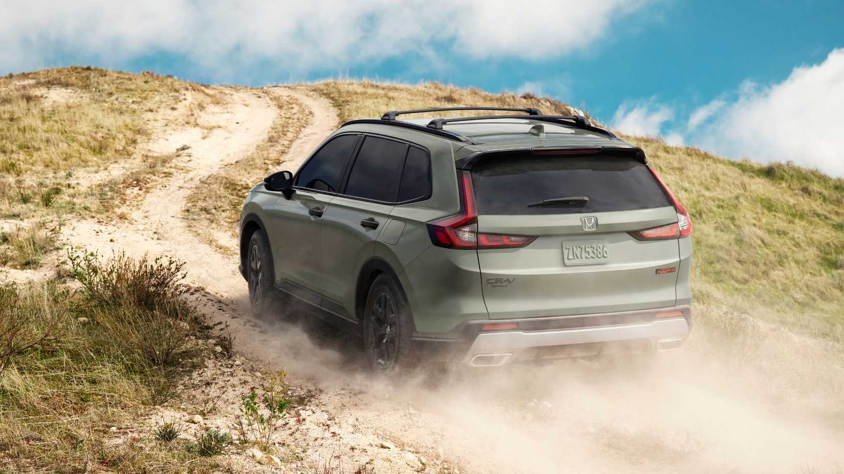Dynamic rear 3/4 shot of a green 2026 Honda CR-V TrailSport off-roading.