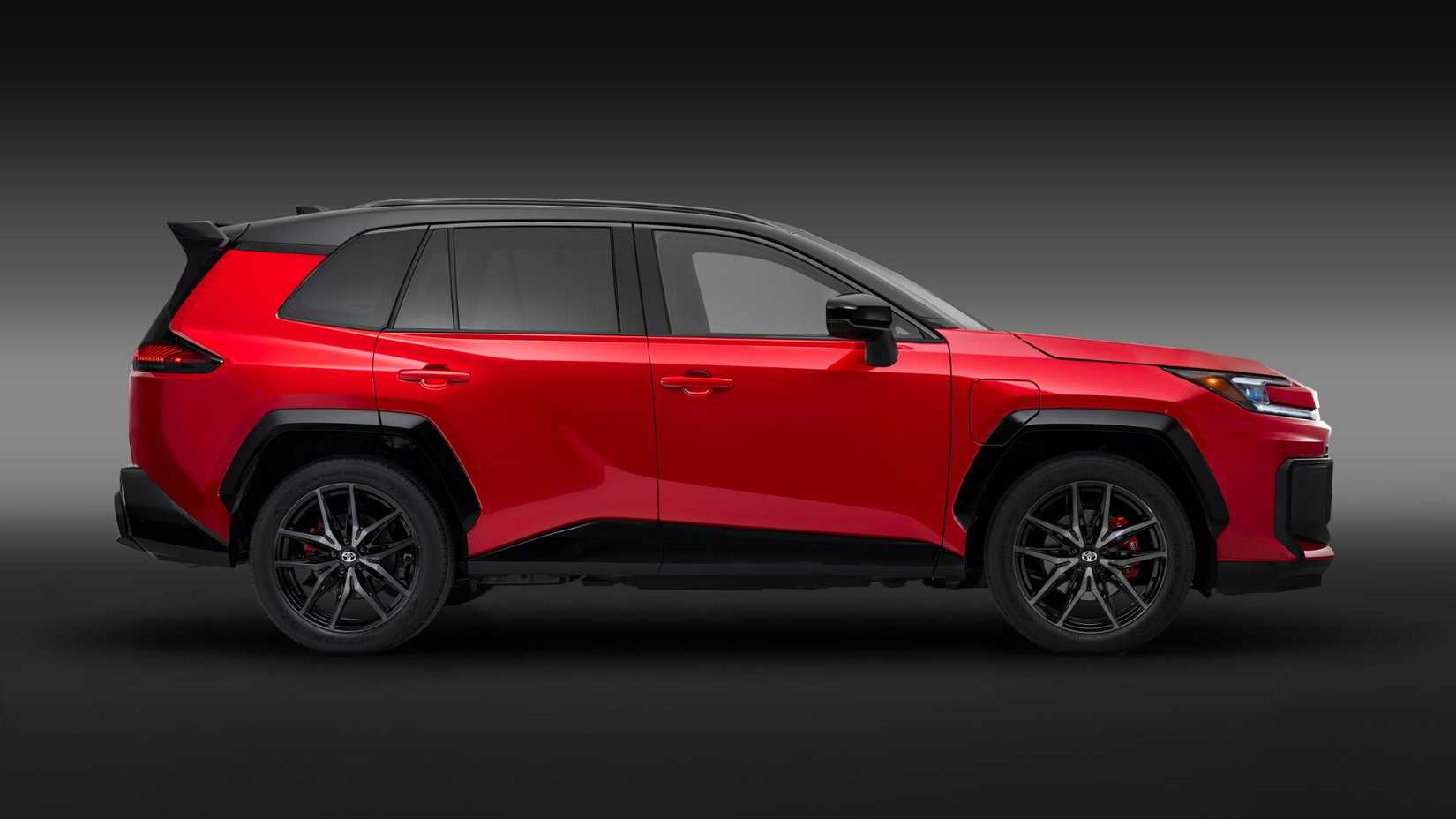 Static side profile shot of a red 2026 Toyota RAV4 PHEV GR Sport in a studio with a black and gray backdrop.