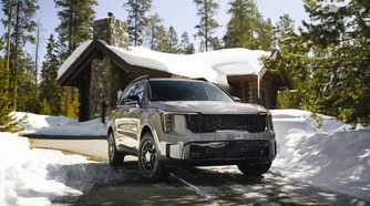 Static frotn 3/4 shot of a 2025 Kia Sorento parked on the driveway of a home after it's snowed.